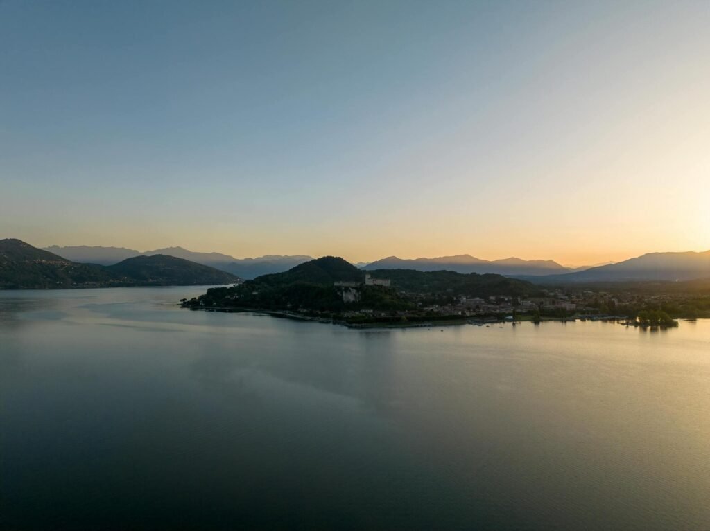 Tramonto sul Lago Maggiore con luce calda e acqua calma