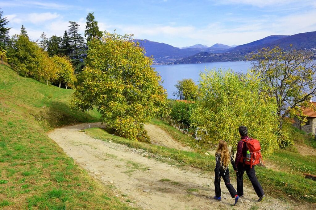 Famiglia in escursione su sentiero collinare con vista sul Lago Maggiore